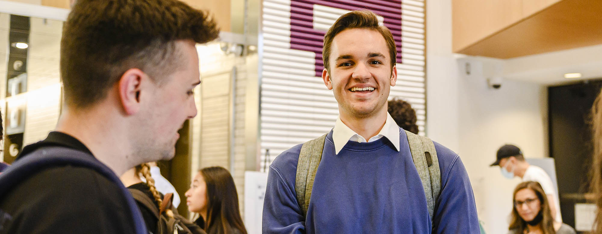 A student smiling and looking directly at a camera.